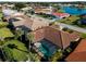 Aerial view showcasing the property's landscaping, screened-in pool, and tile roof at 1678 Quail Lake Dr, Venice, FL 34293