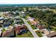 An aerial view shows the house in a wooded neighborhood with lush landscaping at 1678 Quail Lake Dr, Venice, FL 34293