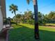 The lovely back yard is full of lush green grass, tropical trees and a screened in pool enclosure at 1678 Quail Lake Dr, Venice, FL 34293