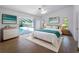 Airy bedroom boasts a king bed, ensuite bathroom access, and a private view of the pool at 1678 Quail Lake Dr, Venice, FL 34293