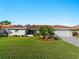 A beautiful lawn highlights the white home with terra cotta roof. The driveway leads to an attached two-car garage at 1678 Quail Lake Dr, Venice, FL 34293