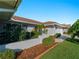 Beautiful home with a well manicured lawn, attractive landscaping, white exterior, and terra cotta roof at 1678 Quail Lake Dr, Venice, FL 34293