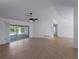 Spacious living room featuring a ceiling fan and sliding doors to the outdoor pool area at 1678 Quail Lake Dr, Venice, FL 34293