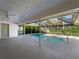 A beautiful covered patio shows the pool with clear blue water and the lush greenery of the landscaped yard at 1678 Quail Lake Dr, Venice, FL 34293