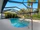 A screened-in pool with a handrail for easy access on a sunny day at 1678 Quail Lake Dr, Venice, FL 34293