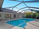 A screened-in pool with a handrail and view of home exterior at 1678 Quail Lake Dr, Venice, FL 34293
