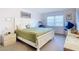 King-size bed, dresser, and TV in this well-lit bedroom at 200 The Esplanade N # A7, Venice, FL 34285