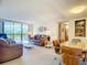 Living room with brown leather sofa and balcony view at 21405 Olean Blvd # 404, Port Charlotte, FL 33952