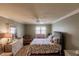 Main bedroom with floral bedding, hardwood floors, and ceiling fan at 2260 Stickney Point Rd # 303, Sarasota, FL 34231