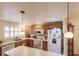 Kitchen with wood cabinets, white appliances, and an island at 2260 Stickney Point Rd # 303, Sarasota, FL 34231
