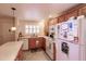 Galley kitchen with wood cabinets and white appliances at 2260 Stickney Point Rd # 303, Sarasota, FL 34231