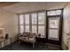 Sunroom features a bench, side table, and large windows with plantation shutters at 2260 Stickney Point Rd # 303, Sarasota, FL 34231