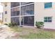 Building exterior with screened balconies and lush landscaping at 2240 Stickney Point Rd # 213, Sarasota, FL 34231