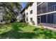 Building exterior view, highlighting the green lawn and screened balconies at 2240 Stickney Point Rd # 213, Sarasota, FL 34231