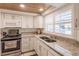 Modern kitchen with white cabinets, granite counters, and stainless steel appliances at 2240 Stickney Point Rd # 213, Sarasota, FL 34231