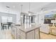 Open-concept kitchen featuring a granite island with seating and stainless steel faucet, blending into the living space at 232 Benedetto Ct, Nokomis, FL 34275