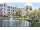 Serene pond with fountain, landscaping, and community building in background at 3000 Ibis Way # 102, Venice, FL 34292