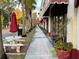 Sidewalk view of shops and restaurants with red awnings at 3730 Cadbury Cir # 400, Venice, FL 34293