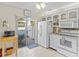White kitchen with view of patio, updated appliances and breakfast bar at 452 Wexford Cir # 105, Venice, FL 34293