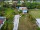 Aerial view of a light blue house with a gravel driveway and lush landscaping at 4533 Church St, Punta Gorda, FL 33980