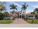 Grand home featuring a beautiful tile roof, manicured lawn, and palm tree landscaping at 457 Anchorage Dr, Nokomis, FL 34275