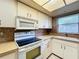 Kitchen with white cabinets and electric range at 509 Parkdale Mews # 509, Venice, FL 34285