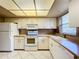 Condo kitchen with white appliances and view to living room at 509 Parkdale Mews # 509, Venice, FL 34285
