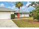 White brick home with an orange door and a palm tree at 5221 Lemon Bay Dr, Venice, FL 34293
