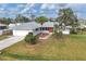 White single-story home with orange door, landscaped yard, and driveway at 5221 Lemon Bay Dr, Venice, FL 34293