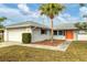 White brick home with attached garage and orange door at 5221 Lemon Bay Dr, Venice, FL 34293