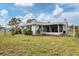 Ranch-style home exterior with a screened patio and lush green lawn at 5221 Lemon Bay Dr, Venice, FL 34293