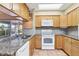 Kitchen with granite countertops and white appliances at 5221 Lemon Bay Dr, Venice, FL 34293