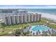 Beautiful beachfront building with a large pool, manicured lawn, and beach access at 5790 Midnight Pass Rd # 602, Sarasota, FL 34242