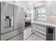 Bright kitchen with stainless steel appliances, custom pantry with beverage center, and sleek white cabinetry, creating a modern culinary space at 5790 Midnight Pass Rd # 602, Sarasota, FL 34242