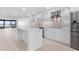 Modern kitchen featuring an island, stainless steel appliances, white cabinetry, and a sleek backsplash, creating a contemporary and functional space at 5790 Midnight Pass Rd # 602, Sarasota, FL 34242