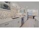 Bright kitchen featuring white cabinetry, tile backsplash, stainless steel appliances, and quartz countertops at 5790 Midnight Pass Rd # 602, Sarasota, FL 34242
