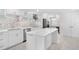 Spacious white kitchen with island seating, modern appliances, and ample counter space, creating a functional and inviting space at 5790 Midnight Pass Rd # 602, Sarasota, FL 34242