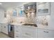 Close-up of a modern kitchen featuring glass cabinets, stainless steel appliances, and unique backsplash, creating a stylish and functional space at 5790 Midnight Pass Rd # 602, Sarasota, FL 34242