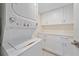 Modern laundry area with stacked washer/dryer and lots of storage at 5790 Midnight Pass Rd # 602, Sarasota, FL 34242