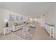 Bright living room with neutral colors, cozy seating, stylish rug, and access to an open-concept kitchen, providing a comfortable and inviting space at 5790 Midnight Pass Rd # 602, Sarasota, FL 34242