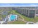 Aerial view of a pool surrounded by a lush green yard and palm trees next to the building at 5790 Midnight Pass Rd # 602, Sarasota, FL 34242