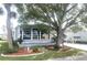 Gray mobile home with large tree and American flag at 727 Blackburn Blvd, North Port, FL 34287