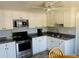 Well-lit kitchen featuring granite countertops, stainless steel oven, microwave, and white cabinetry at 113 Colonia W Ln, Nokomis, FL 34275