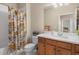 Bathroom featuring a shower and tub combo, floral shower curtain, vanity with a sink and decorative items at 12837 Oriago St, Venice, FL 34293