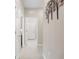 Neutral hallway with tiled flooring, white trim and doors, and modern metal tree-themed wall decor at 12837 Oriago St, Venice, FL 34293
