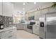 Modern kitchen with stainless steel appliances, gray cabinets, granite countertops, and a decorative backsplash at 12837 Oriago St, Venice, FL 34293