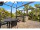 Covered patio features brick flooring, dining table, and a hot tub perfect for relaxing in a tropical setting at 12837 Oriago St, Venice, FL 34293
