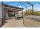 Screened patio area features comfortable seating, a dining table, and a luxurious hot tub, ideal for relaxation at 12837 Oriago St, Venice, FL 34293