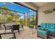Screened-in patio featuring a hot tub, table with chairs, wicker couch, and views of tropical landscaping at 12837 Oriago St, Venice, FL 34293