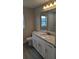 Bathroom featuring granite countertops, white cabinets, and wood look tile flooring at 14464 Fort Myers Ave, Port Charlotte, FL 33981